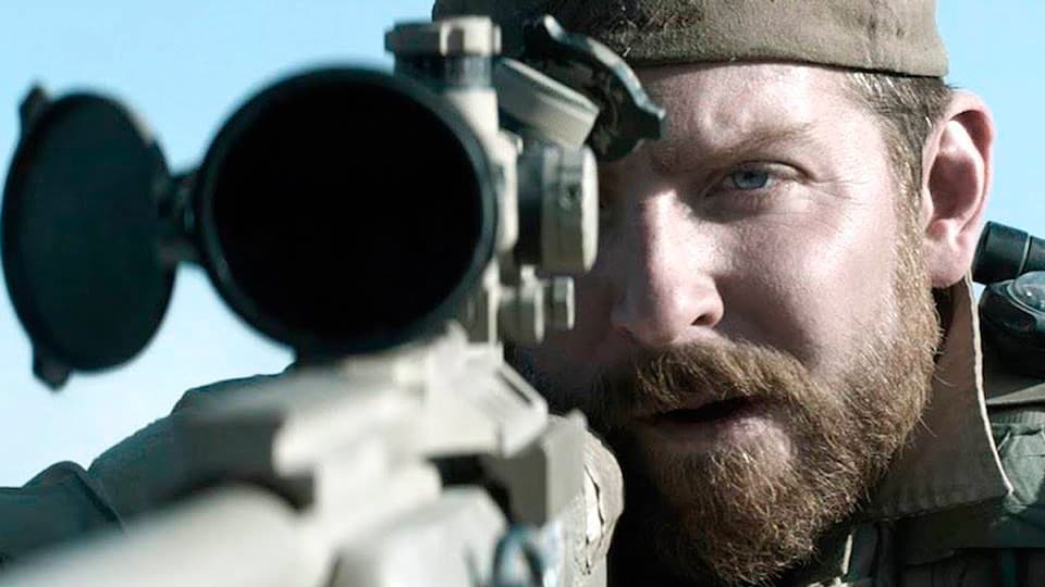 American Sniper screenplay hero image featuring Bradley Cooper looking through a scope mounted to a long rifle.
