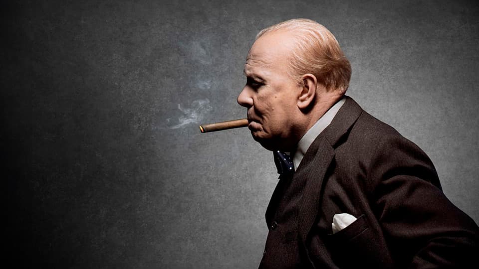 Darkest Hour screenplay hero image with Gary Oldman as Winston Churchill, profile shot, smoking a cigar.